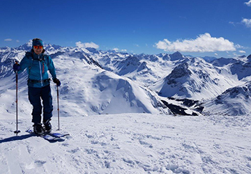 Skitourenfahrer vor verschneitem Bergpanorama